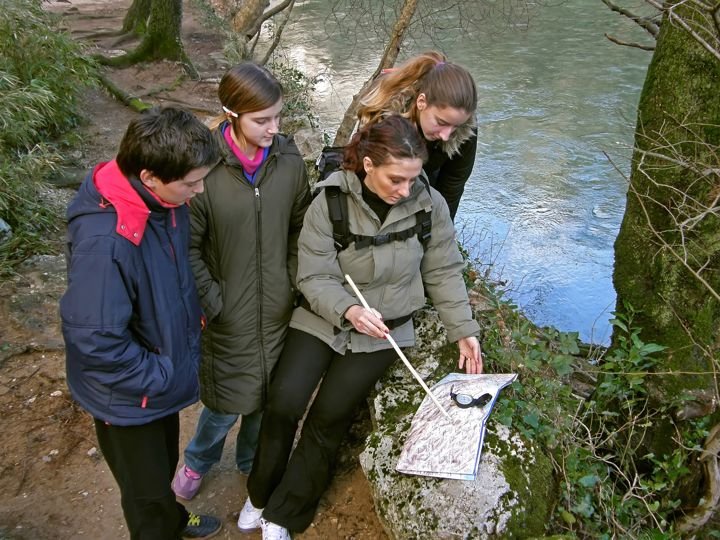 group orienteering in nature with hiking compass and map